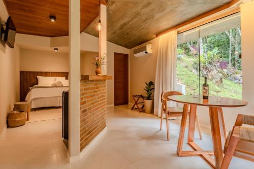 a room with a table and a bed and a window at Vila da toca in Ibitirama