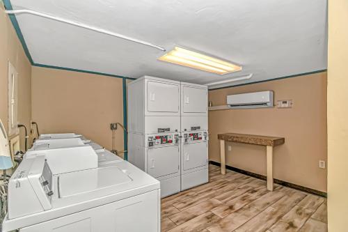 Cette chambre comprend des appareils électroménagers blancs et une table. dans l'établissement Cozy 1 Bedroom Oceanview Condo! City and Ocean Views!, à Myrtle Beach