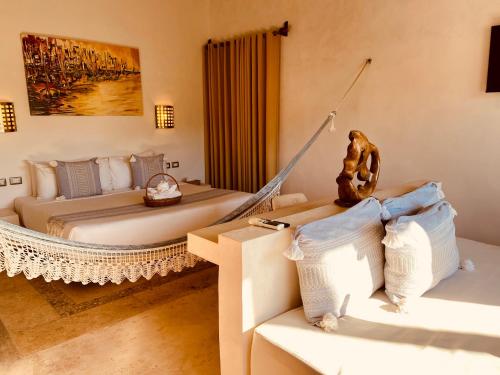 a bedroom with two beds and a hammock at Hotel Para Ti - Adults Only in Holbox Island