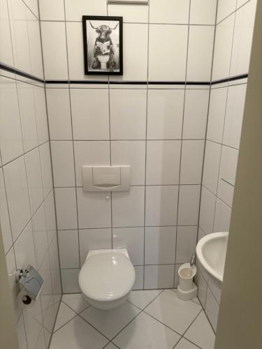 a white bathroom with a toilet and a sink at Sehr schöne Wohnung 100 qm zentrale Lage 5 min nach Aachen in Würselen