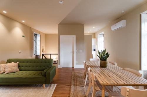a living room with a green couch and a table at Estação de Mosteirô, Next Stop - by RowdHouses in Riba Douro