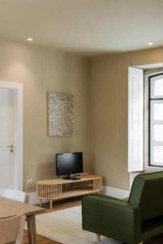 a living room with a flat screen tv on a table at Estação de Mosteirô, Next Stop - by RowdHouses in Riba Douro