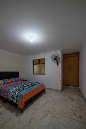 een slaapkamer met een bed en een ventilator bij Belén Vibe in Medellín