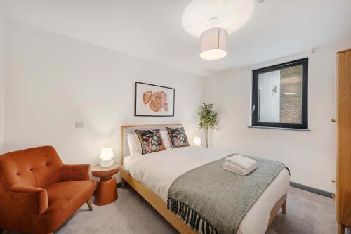 a bedroom with a bed and a chair and a window at Baltic Apt II - City Centre with Parking, Sleeps 6 in Liverpool