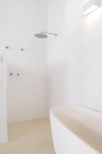 a white bathroom with a shower and a sink at Miradouro de São Sebastião in São Sebastião