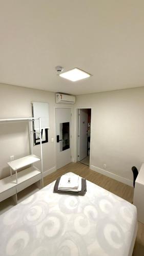 a room with a bed with a table on it at Quarto individual Vila Olimpia in Sao Paulo