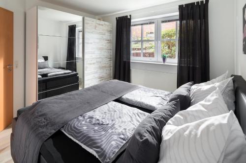ein großes Bett in einem Schlafzimmer mit einem Spiegel in der Unterkunft Apartment Emsköpken in Norderney