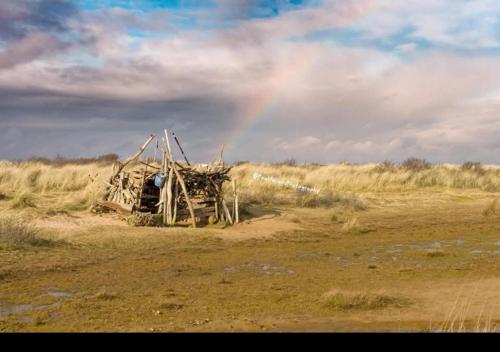 a rainbow in the middle of a field with a house at The annex theddlethorpe Lincolnshire in Theddlethorpe Saint Helen