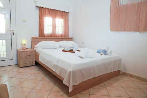 a bedroom with a bed with white sheets and a window at Ioli Luxury Apartment in Gourna