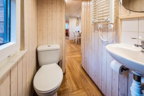 a bathroom with a toilet and a sink at Domek lubiana180 SCANDI wśród drzew jacuzzi taras na dachu jezioro Kaszuby Pieski tylko do 10kg za dodatkową opłatą in Grzybowo