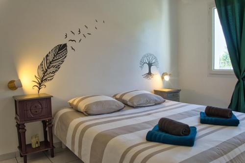 - une chambre dotée d'un grand lit avec des oiseaux sur le mur dans l'établissement Maison La Rose des Vents, avec WIFI, proche plage et commerces, à Brem-sur-Mer