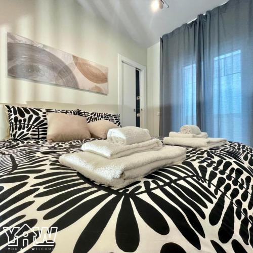 a black and white bed with towels on it at Lucia's House in San Giovanni Rotondo