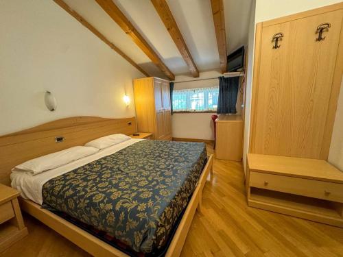 a bedroom with a bed in a room at Hotel Caminetto - Rooms and Apartments in Cembra