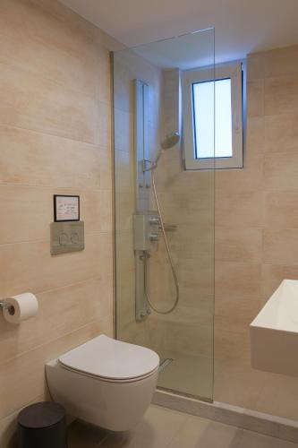 a bathroom with a shower and a toilet and a sink at AD ASTRA Comfort Living in Preveza