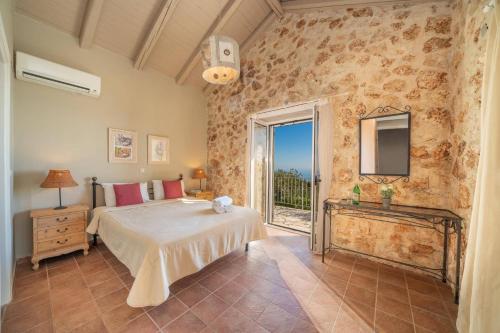 a bedroom with a bed and a large window at Villa Ifandis by Villa Plus in Ratzaklíon