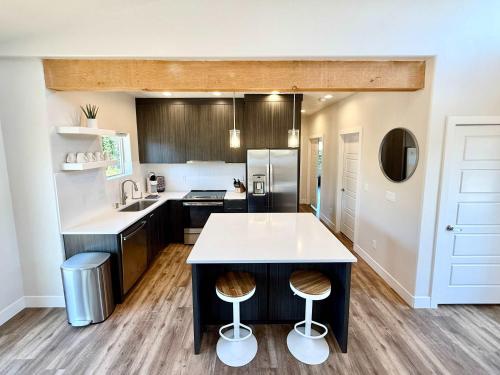 a kitchen with a counter and stools in it at Timber & Tin H 2Bed 2Bath w Pool & Rooftop Deck in Kanab