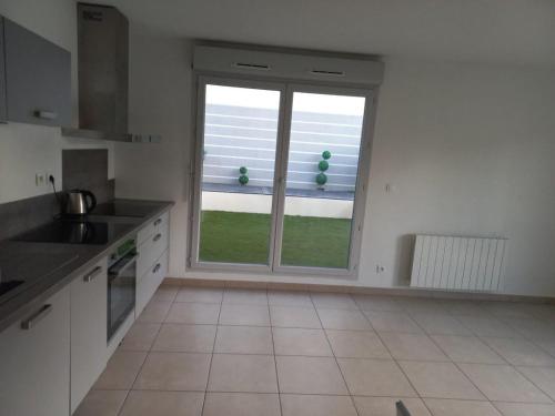 - une cuisine avec une grande fenêtre dans une chambre dans l'établissement T2 Villefranche, à Villefranche-sur-Saône