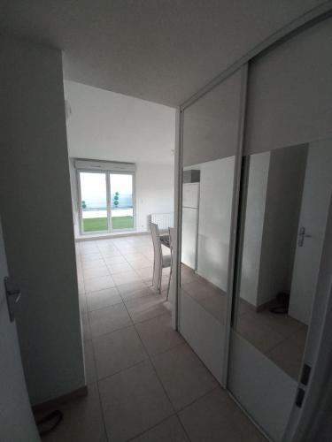 une chambre vide avec une table, des chaises et une fenêtre dans l'établissement T2 Villefranche, à Villefranche-sur-Saône