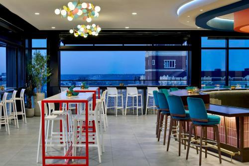 a restaurant with tables and chairs and a view of the city at Hotel Celare, Cincinnati Midtown, a Tribute Portfolio Hotel in Cincinnati