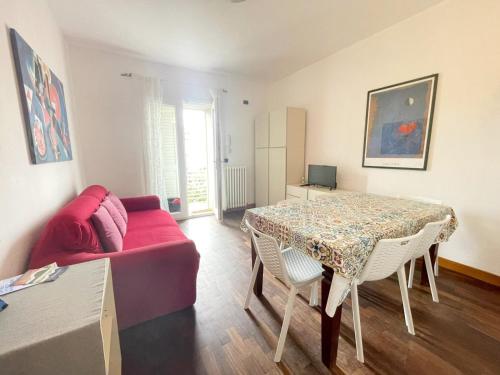 a living room with a table and a red couch at Appartamento da Gigi a Marina di Cecina by Zoom In Earth in Marina di Cecina