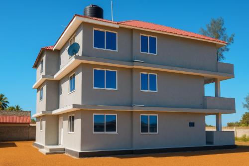 a building with blue windows on top of it at 2BR Beachfront Apartment with Balcony & Sea Views - Uroa, Zanzibar in Uroa