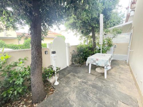 a patio with a table and a tree at Appartamento da Gigi a Marina di Cecina by Zoom In Earth in Marina di Cecina