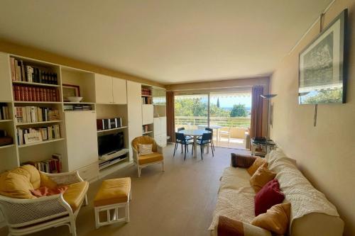 un salon avec un canapé, des chaises et une table dans l'établissement Cozy flat with terrace and swimming pool in Cannes, à Cannes