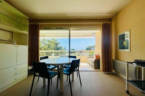une cuisine et une salle à manger avec une table et des chaises dans l'établissement Cozy flat with terrace and swimming pool in Cannes, à Cannes