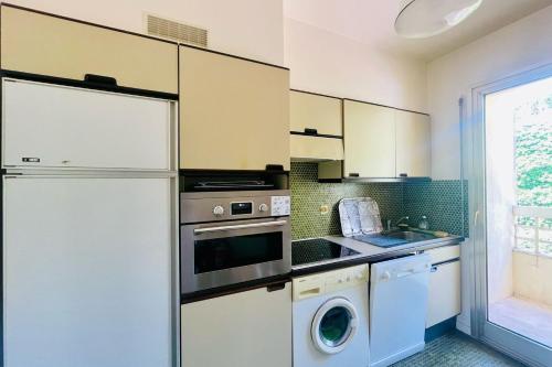 Il comprend une cuisine équipée d'un réfrigérateur et d'un lave-linge/sèche-linge. dans l'établissement Cozy flat with terrace and swimming pool in Cannes, à Cannes