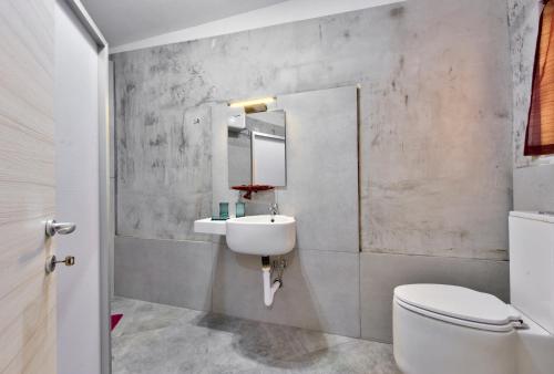 ein Badezimmer mit einem Waschbecken, einem WC und einem Spiegel in der Unterkunft Central Suites in St Paul's Bay