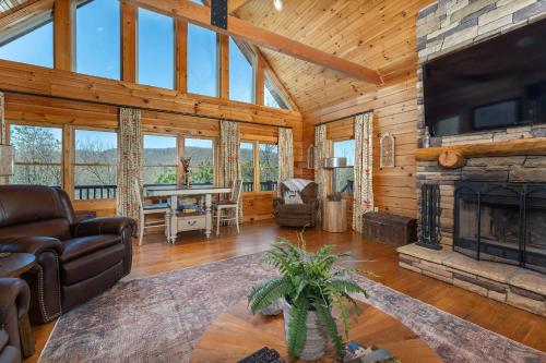 a living room with a fireplace in a log cabin at About the View in Black Mountain