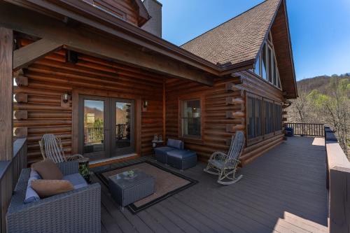 a porch of a log cabin with chairs and tables at About the View in Black Mountain