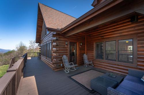 a wooden deck with chairs and a couch on a cabin at About the View in Black Mountain