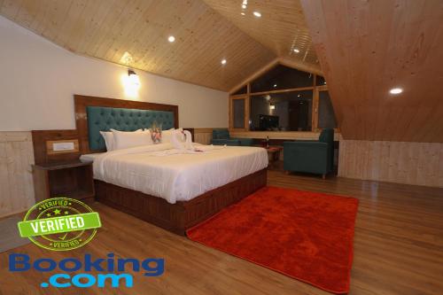 a bedroom with a large bed and a red rug at Hidden Heaven Old Manali club house road in Manāli