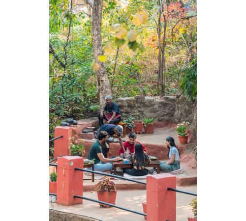 a group of people sitting around a table in a park at Jungle Ghar in Pachmarhī