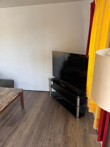 a living room with a large flat screen tv at La Hacienda Motel in Seattle