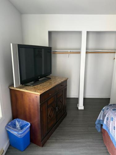 a room with a television on a dresser with a bed at La Hacienda Motel in Seattle
