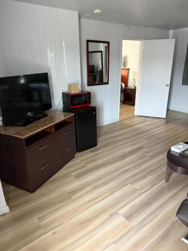 a living room with a television and a wooden floor at La Hacienda Motel in Seattle