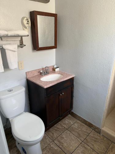 a bathroom with a toilet and a sink at La Hacienda Motel in Seattle