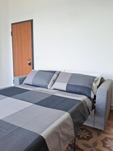 a large bed with blue and gray sheets on it at Almarè House in Giardini Naxos