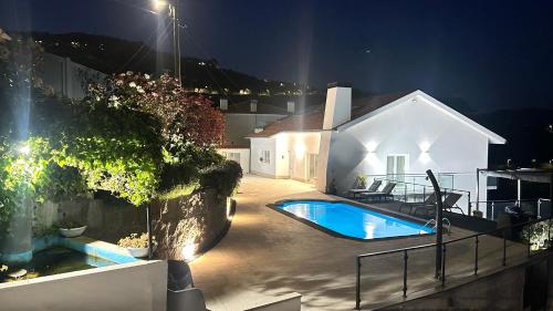 a swimming pool in the backyard of a house at night at Casa Vale do Douro in Mesão Frio