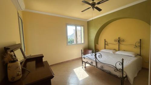 una camera da letto con un letto e un ventilatore a soffitto di Mare Nostrum Apartment a Marina di Ragusa