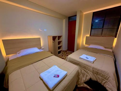 a bedroom with two beds with towels on them at La soledad in Huaraz