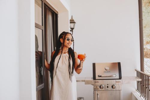 a woman in a white dress holding a flower at El Prado: New 2br Condo in Las Catalinas in Playa Danta