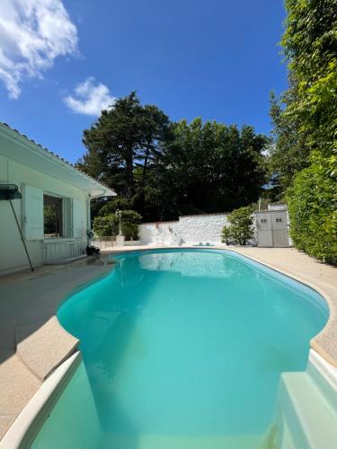 une piscine avec de l'eau bleue dans une cour dans l'établissement Villa Spacieuse avec Piscine Privée, à Biarritz