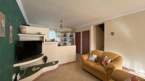 un soggiorno con divano e TV a schermo piatto di Mare Nostrum Apartment a Marina di Ragusa