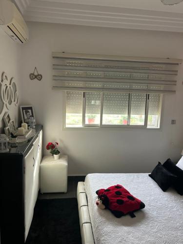 a bedroom with a bed with a red pillow on it at Perla Saidia, Appartement F2, Idéal pour une famille, Plage à 5min à pied, Piscine en travaux in Saidia 