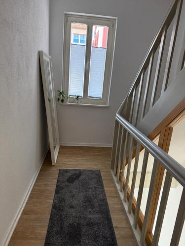 an empty hallway with stairs and a window at Ferienwohnung Karschter Reisehäusle in Karlstadt
