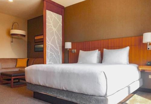 a bedroom with a large white bed and a couch at Hyatt Place Houston- Northwest/Cy-Fair in Houston