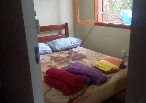 una camera con un letto con asciugamani colorati di Caminho de Santiago a São Bento do Sapucaí